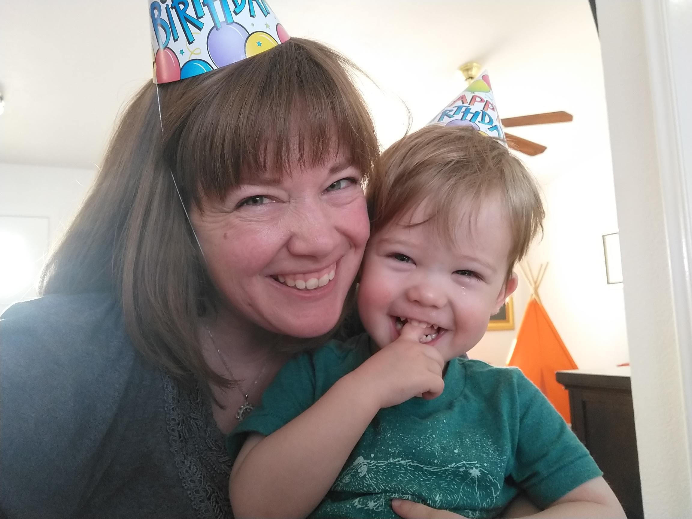 Kelly and Alexander smiling with birthday hats on